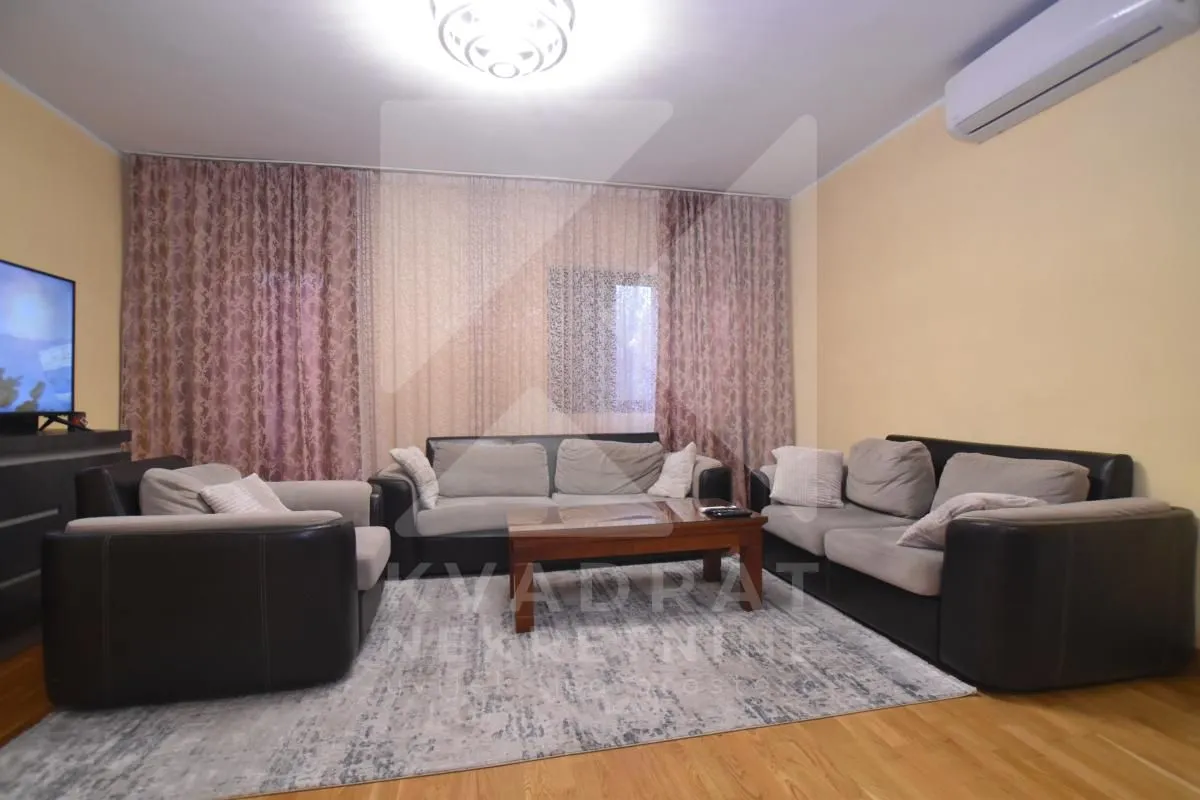 Living room furnished with a sofa set, coffee table, and television.