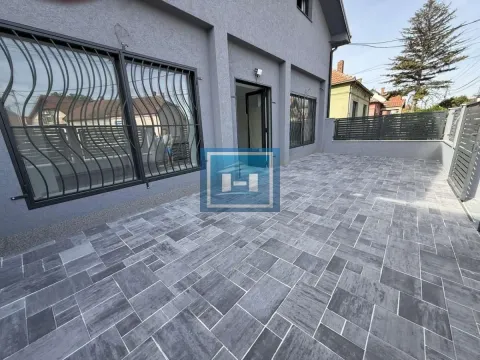 Paved courtyard in front of the house with a fence and window security bars. - image 2