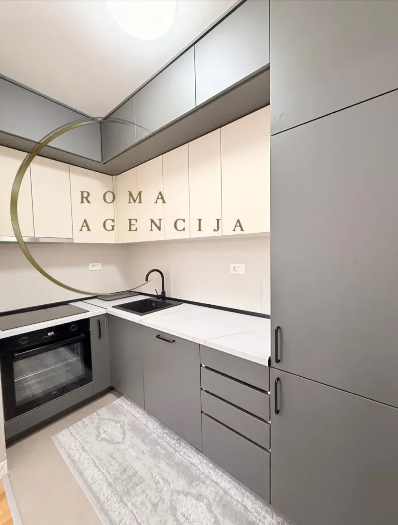 Modern kitchen with grey cabinets and a built-in oven.