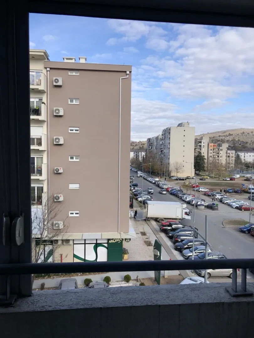 View from the balcony overlooking the street and neighboring buildings.