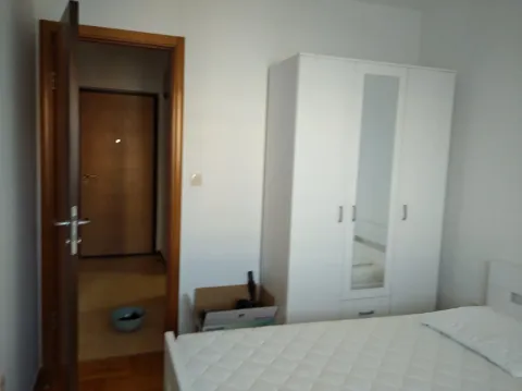 Spavaća soba sa krevetom, bijelim garderoberom i otvorenim vrata prema hodniku. - image 9