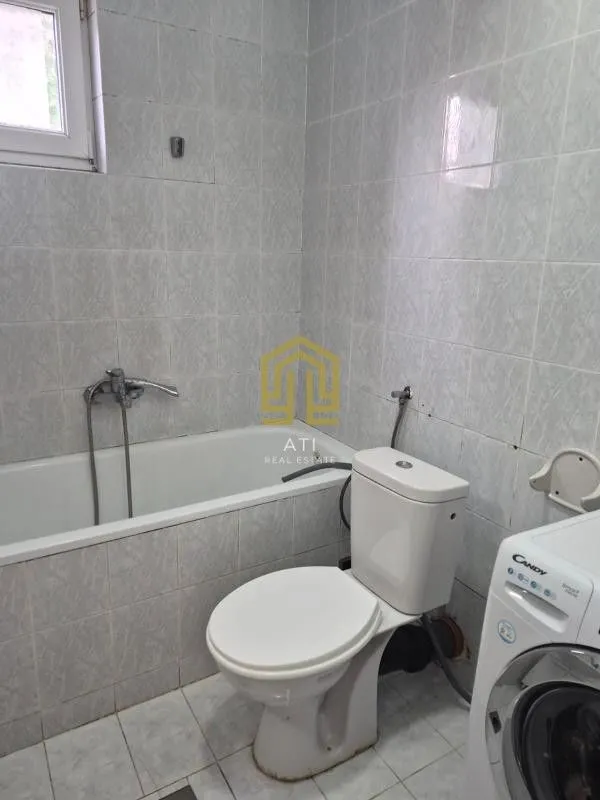 Manje opremljeno kupatilo sa kadom, wc šoljom i veš mašinom.