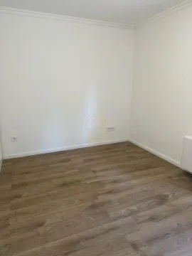 Empty room with white walls and laminate flooring. - image 5