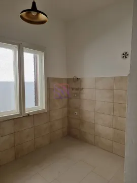 Empty kitchen with wall tiles and a window. - image 13