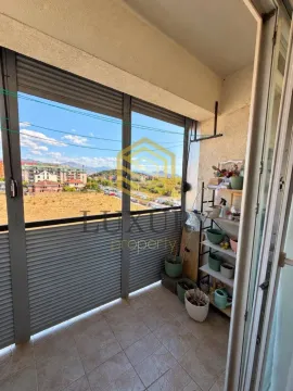 Glazed balcony with a flower shelf and a neighborhood view. - image 3
