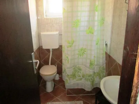 Manje kupatilo sa wc šoljom, lavaboom i tuš kabinom sa zavesom. - image 9