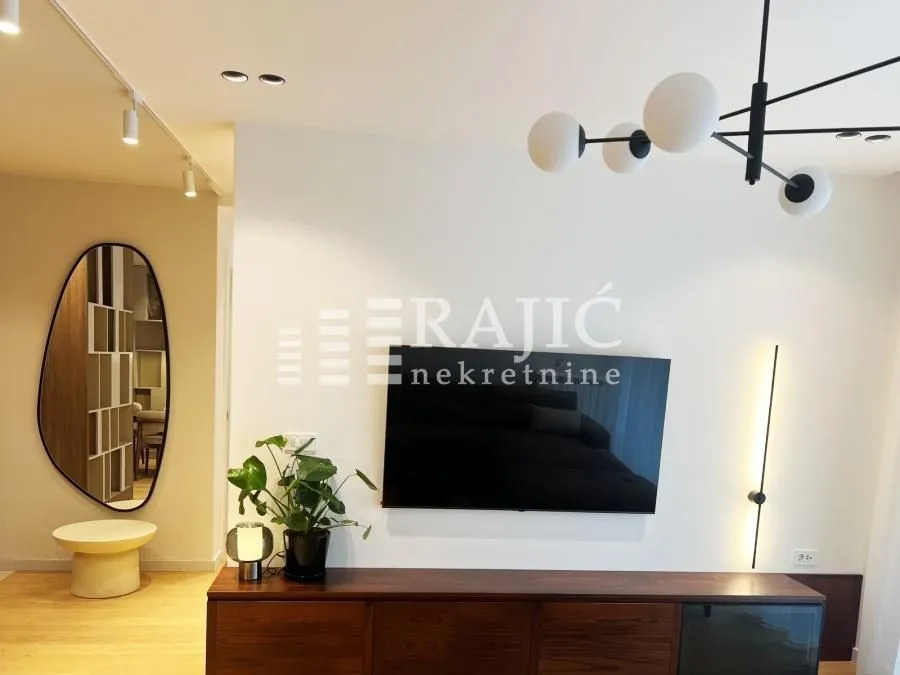 Modern living room with TV and decorative lighting.