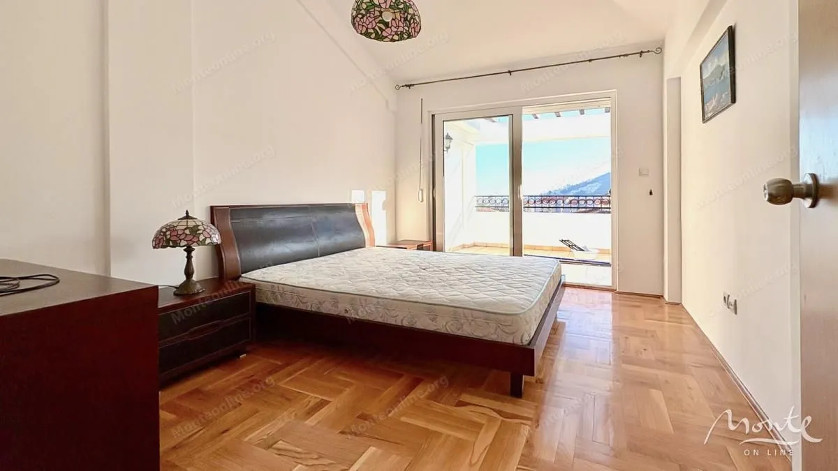 Spavaća soba sa bračnim krevetom i izlazom na terasu.