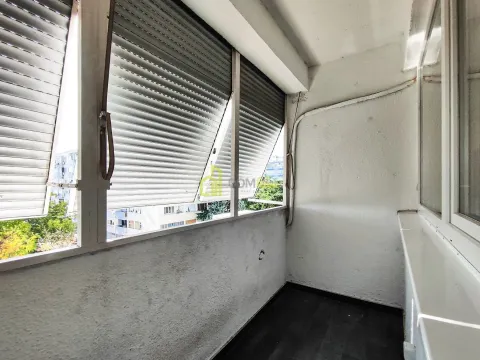 Zastakljeni balkon sa roletnama i pogledom na okolne zgrade. - image 3