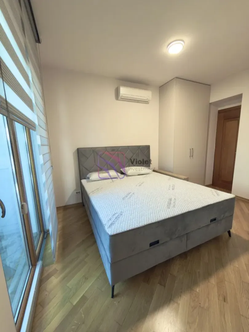Spavaća soba sa bračnim krevetom, plakarom i izlazom na terasu.
