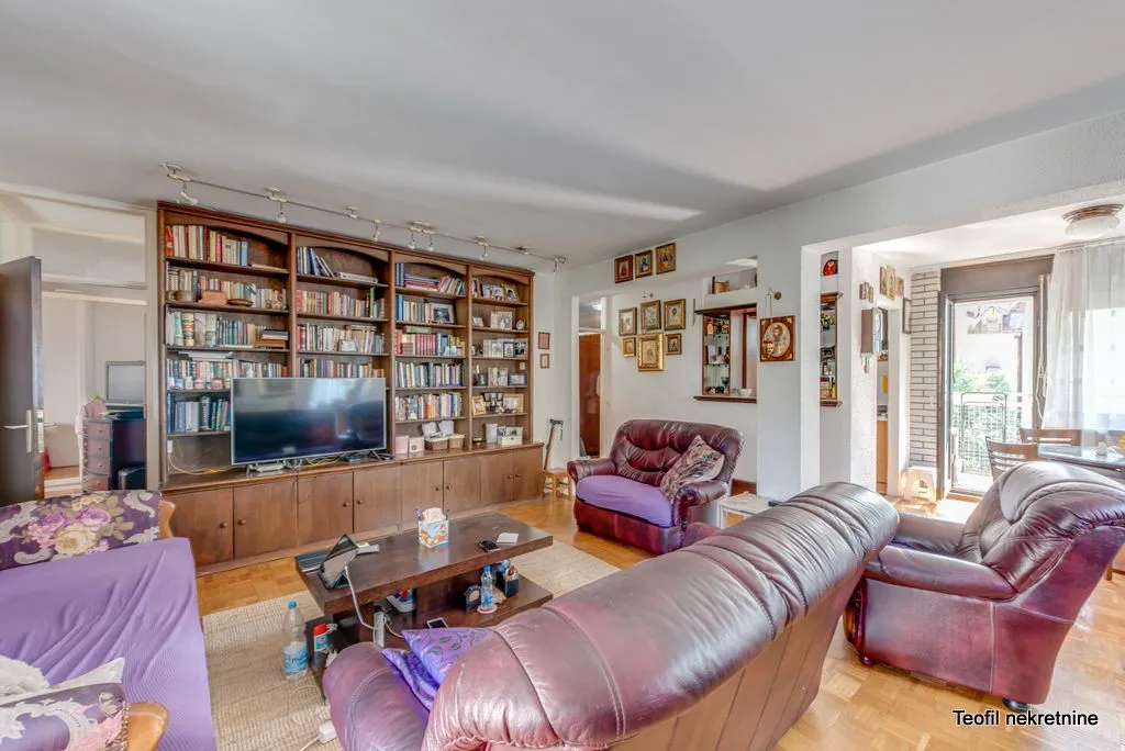 Living room with a large wooden bookcase, seating furniture, and a television.