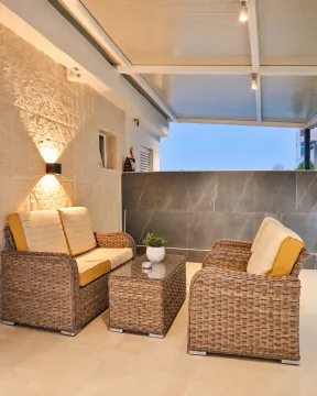 Covered terrace with seating furniture and lighting. - image 9