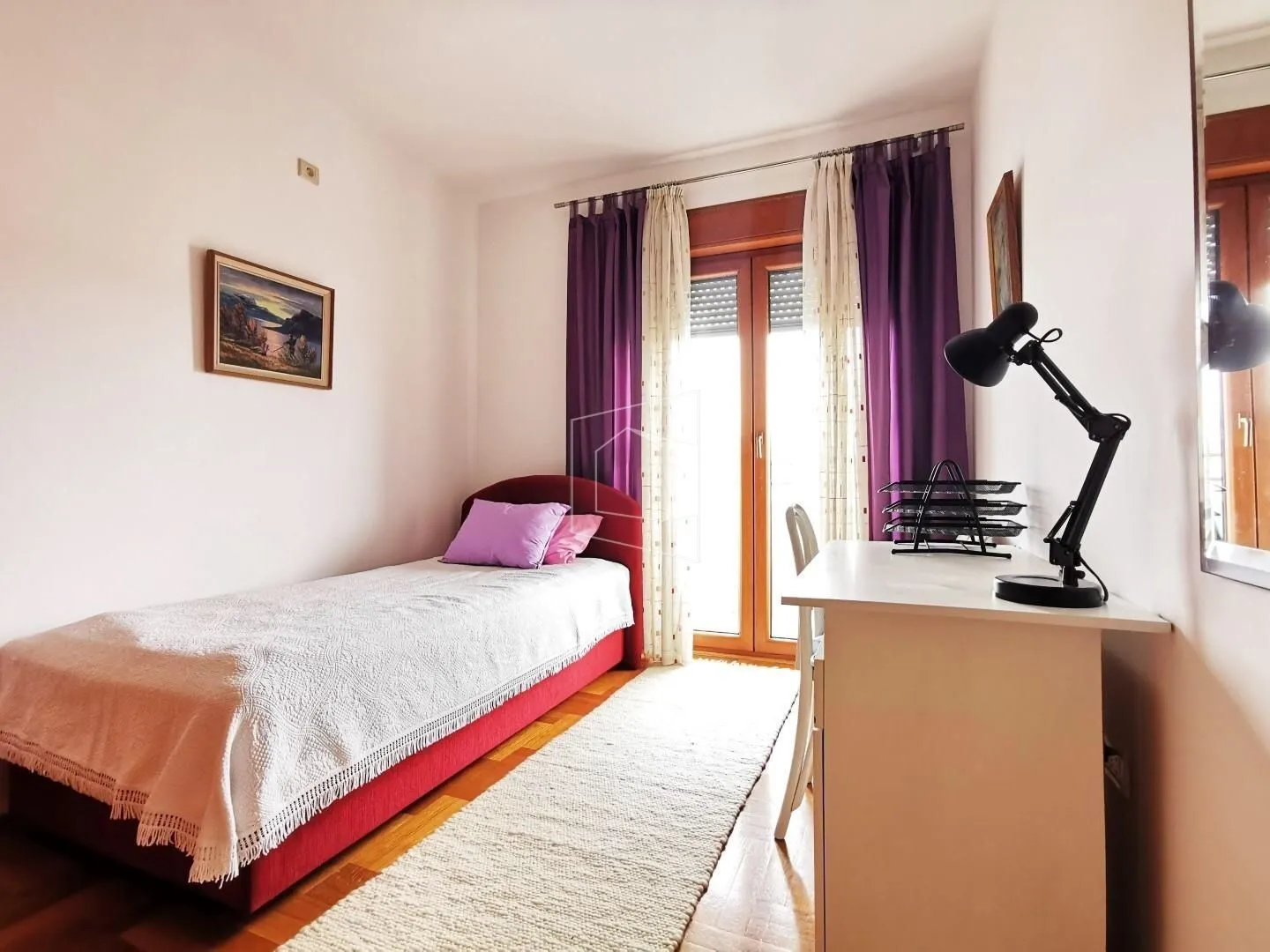 Bright bedroom with a single bed and a desk.