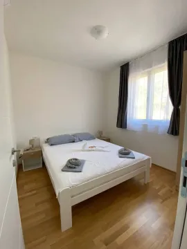 Furnished bedroom with a double bed, wooden floor and a window. - image 3