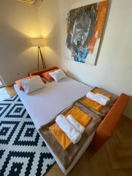 Svijetla spavaća soba sa bračnim krevetom i umjetničkom slikom na zidu. - image 14