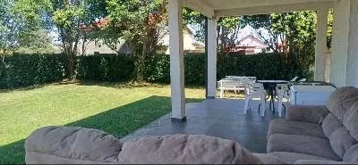Covered terrace with seating furniture and a view of the yard. - image 9
