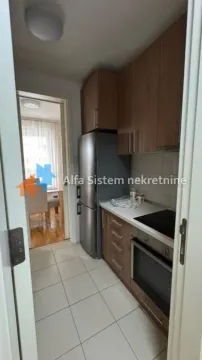 Pogled na manju kuhinju sa drvenim elementima i ugradnim uređajima. - image 10