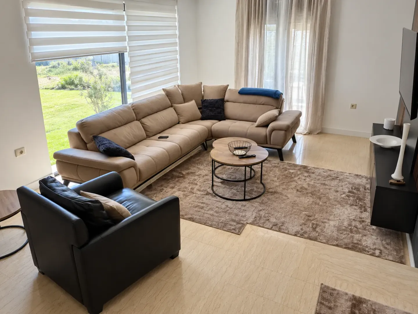 Spacious living room with a sectional sofa, armchair, and view of the yard.