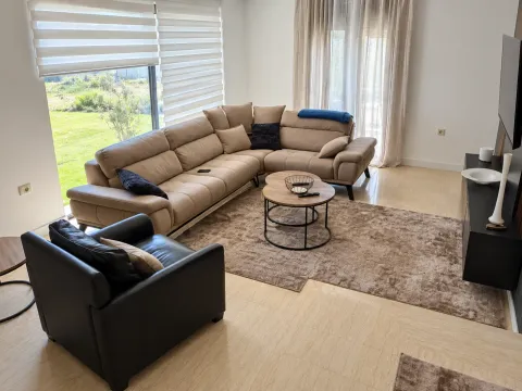 Spacious living room with a sectional sofa, armchair, and view of the yard. - image 5