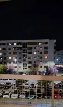 Pogled noću sa terase na susjednu zgradu i parking sa automobilima. - image 4