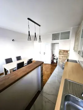 Kitchen with a breakfast bar and dining area. - image 7