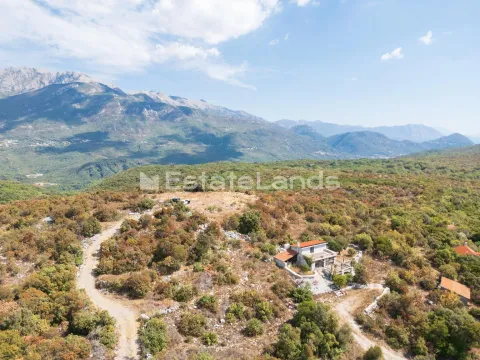 Pogled iz vazduha na kuću okruženu prirodom i planinama. - image 10