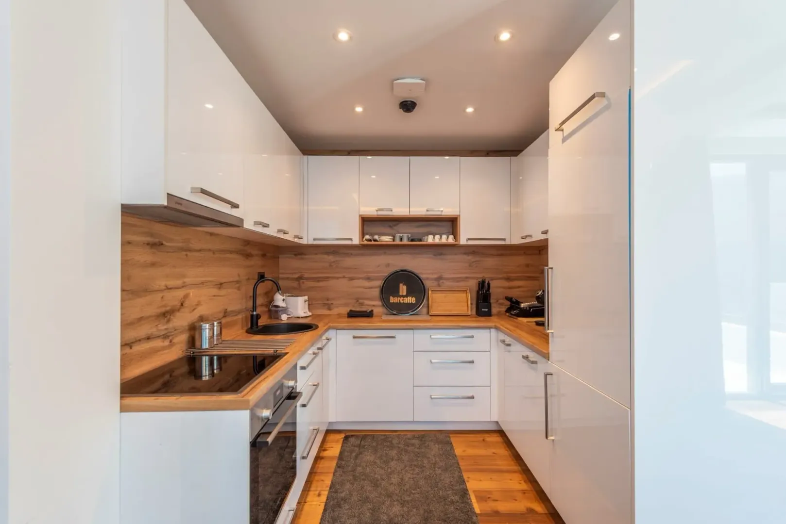 Modern white kitchen with wooden details.