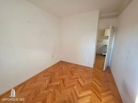 Prazna soba sa parketom i otvorenim vratima prema drugoj prostoriji. - image 9