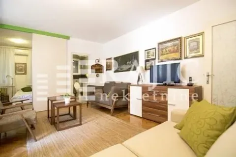Living room with a sofa, chest of drawers, and television. - image 2