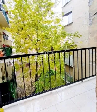 View from the balcony overlooking trees and surrounding buildings. - image 19