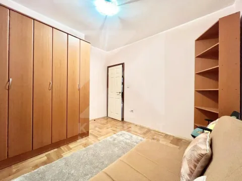 Manja spavaća soba sa velikim drvenim ormarom, kaučem i policom. - image 11