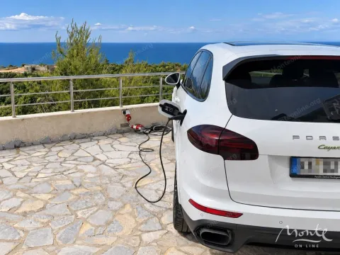 Automobil parkiran na popločanom dvorištu sa pogledom na more. - image 16
