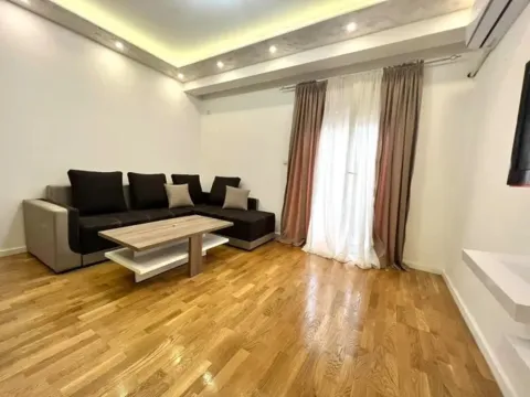Living room with sofa, coffee table, and hardwood flooring. - image 2