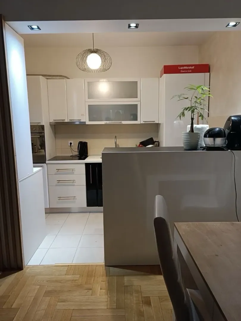 Pogled na modernu i urednu kuhinju sa bijelim elementima.