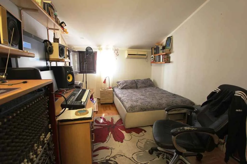 Manja spavaća soba sa krevetom i muzičkom opremom.