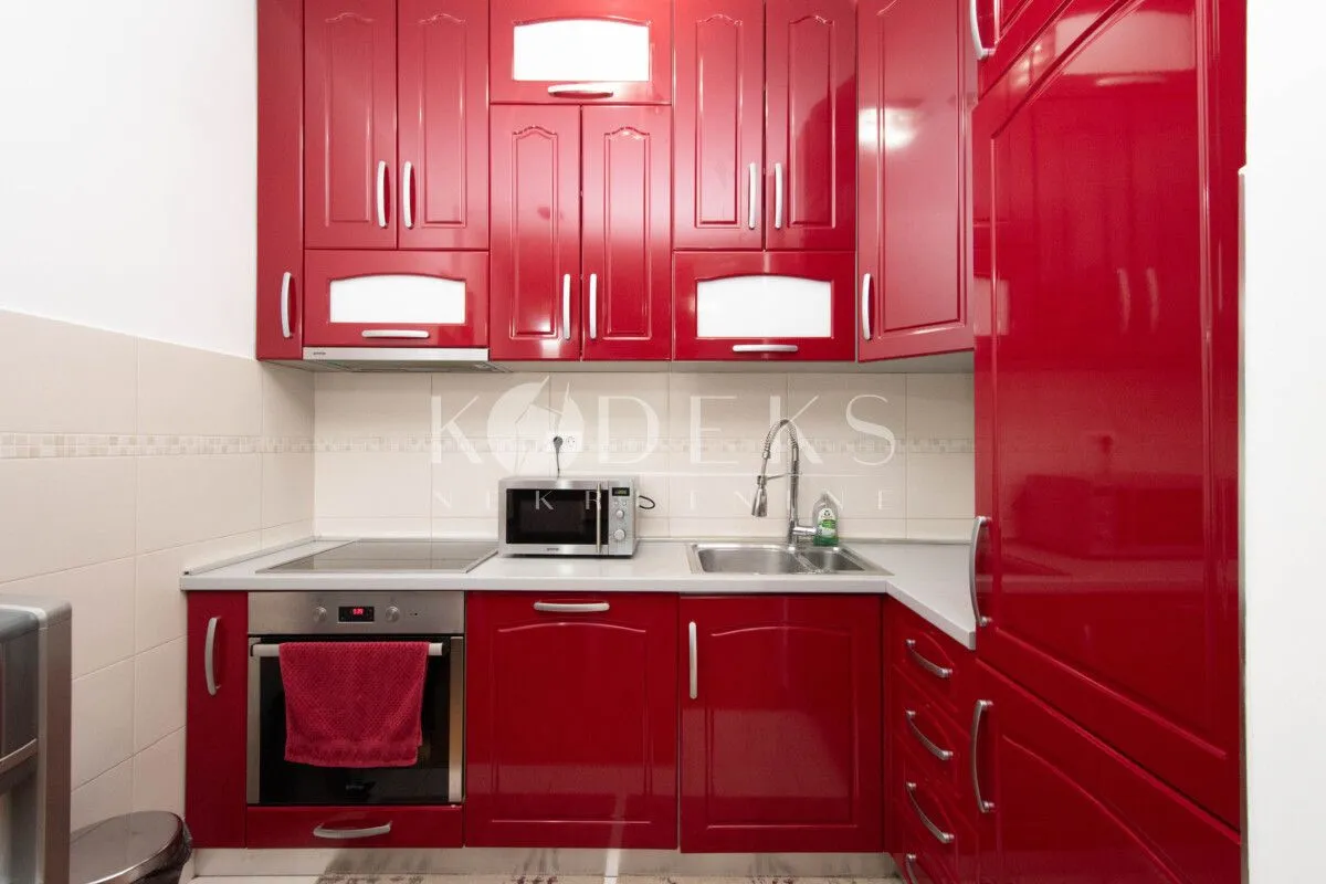 Kitchen with red high-gloss cabinets and built-in appliances.