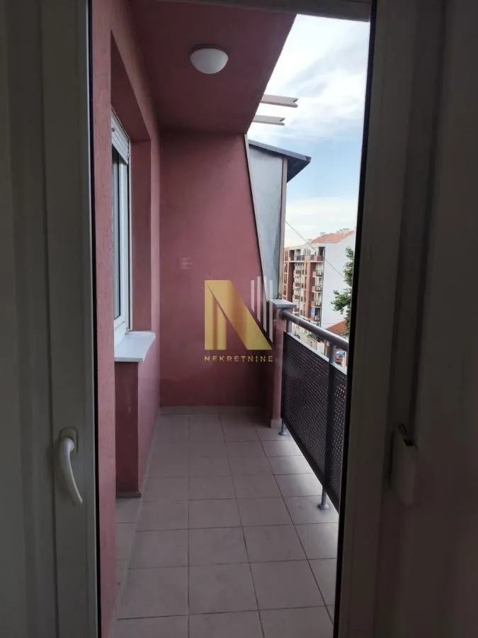 Pogled na natkrivenu terasu sa keramičkim pločicama i ogradom.