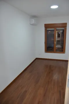 An empty room with laminate flooring and a window. - image 5