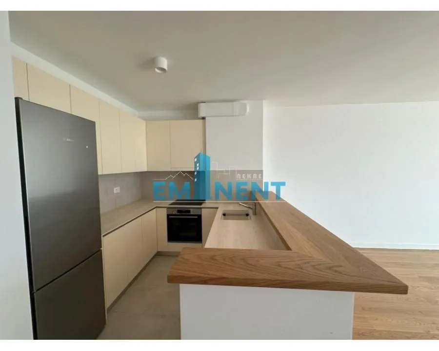 Kitchen equipped with light-coloured cabinets and a wooden counter.