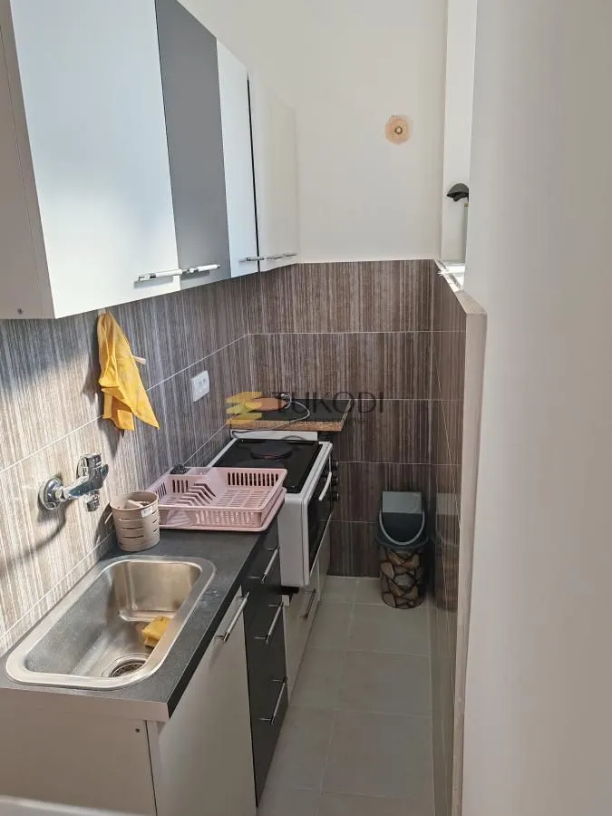 Small kitchen with a sink, cabinetry, and a stove.