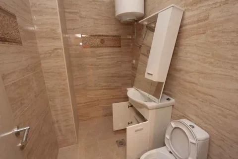 Jednostavno kupatilo sa svijetlim pločicama, lavaboom i ogledalom. - image 19