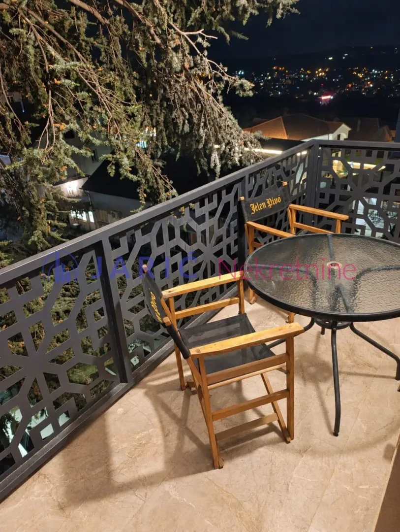 Balcony with seating furniture and a view of the night city.
