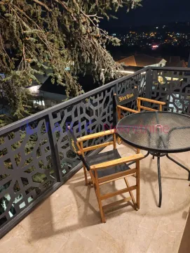 Balcony with seating furniture and a view of the night city. - image 15