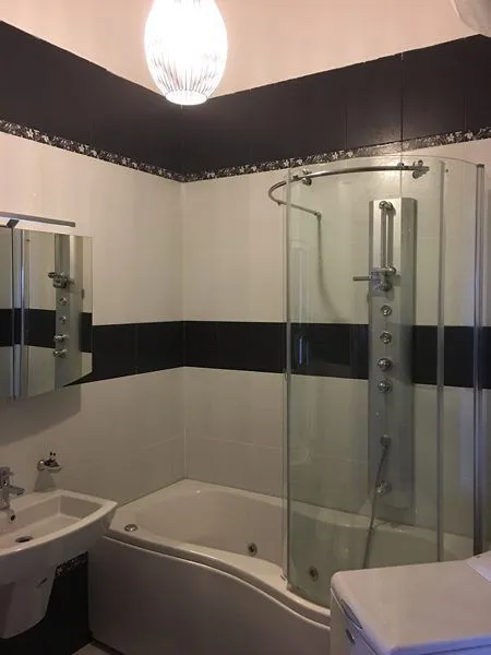 Bathroom with a bathtub, shower cabin, and washbasin.