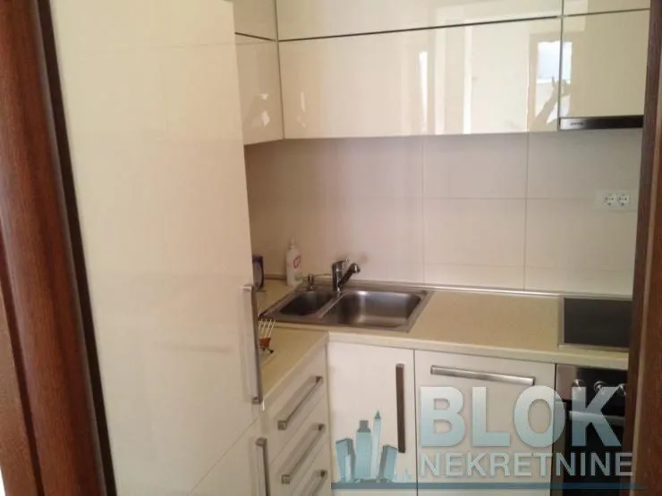 Smaller kitchen with white cabinets and a sink.