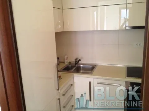 Smaller kitchen with white cabinets and a sink. - image 8