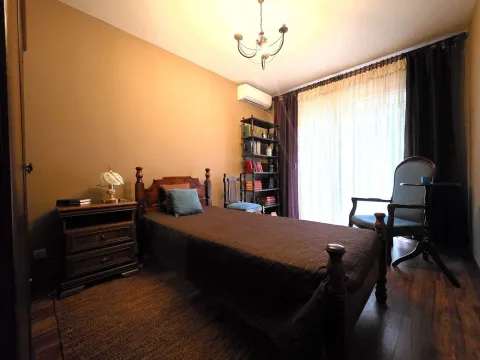 Furnished bedroom with a bed, nightstand, and bookcase. - image 9