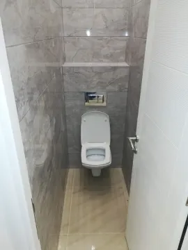 Smaller bathroom with gray tiles and a wall-hung toilet. - image 6