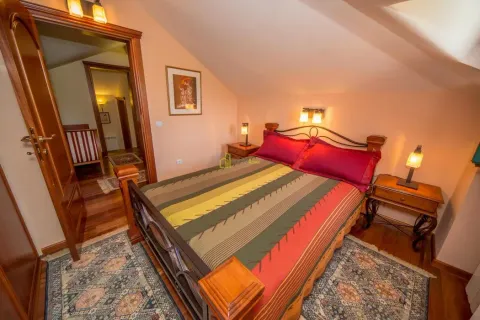Furnished bedroom with a double bed and wooden flooring. - image 26