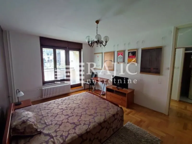 Furnished bedroom with a double bed, TV cabinet, and access to the terrace.